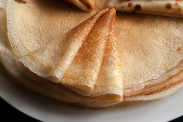 Pancakes, pancakes on a plate, dark background.