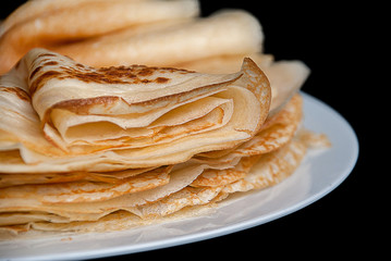 Pancakes, pancakes on a plate, dark background.