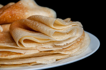 Pancakes, pancakes on a plate, dark background.