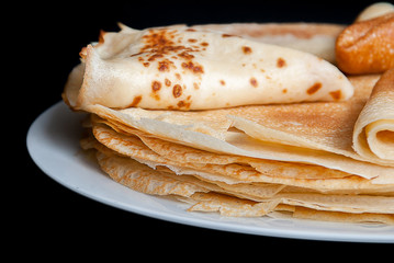 Pancakes, pancakes on a plate, dark background.