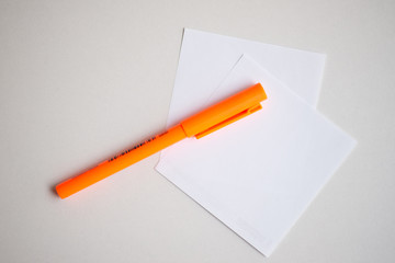 White paper with orange pen.