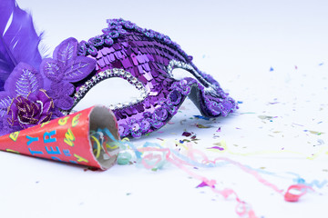Violet masks on white background with paper firework for celebration. Carnival or Carnival Sunday concept. © Phongsakorn