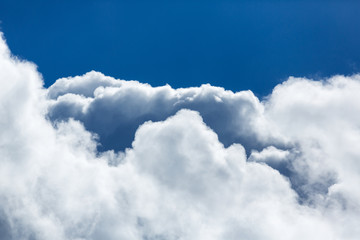 Naklejka na ściany i meble Blue sky covered in large puffy cumulonimbus cloud formations