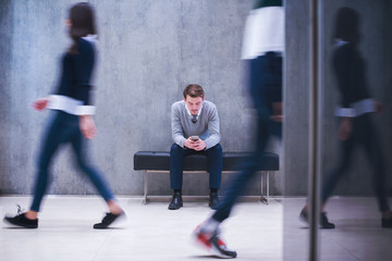 businessman using mobile phone while sitting on the bench