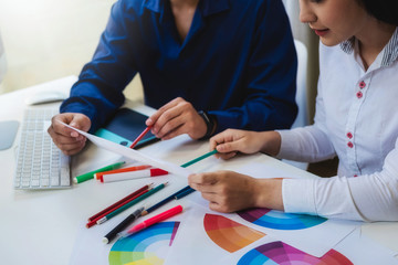 Two designer graphic creative people working about select color swatch samples for create new...