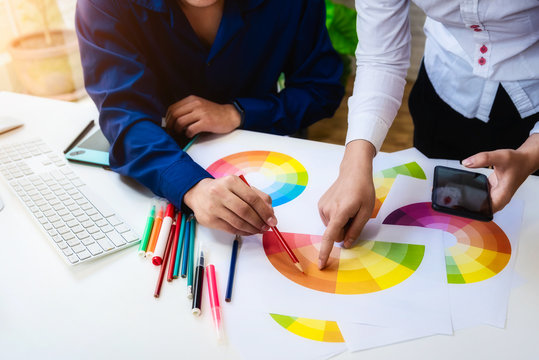 Designer graphic designer using color swatch sample with mobile phone on artist workplace. graphics design concept.