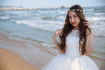 Fototapeta na wymiar Portrait of beautiful bride with wedding makeup, hairstyle and jewelry wreath on long curly hair.