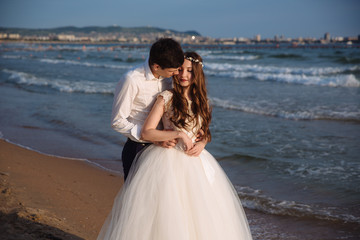 Fototapeta na wymiar Lovers newlyweds look at each other and spend time together on ocean beach