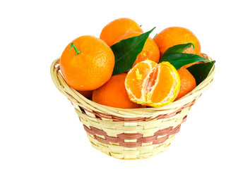 Bunch of fresh tangerines, clementines or mandarins in basket and leaves close up.