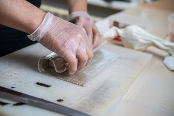 Cook hands making japanese sushi roll. Japanese chef at work preparing delicious sushi roll with eel and avocado. Appetizing japanese food.