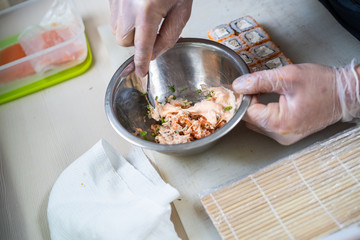 Cook hands making japanese sushi roll. Japanese chef at work preparing delicious sushi roll with eel and avocado. Appetizing japanese food.