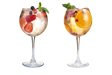 Two refreshing alcoholic or non-alcoholic cocktails with mint, fruit and berries on a white background. Cocktails in glass goblets.