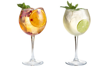 Two light alcoholic or non-alcoholic cocktails with mint, fruits and berries on a white background. Cocktails in glass goblets.