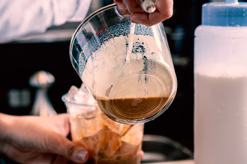 Barista making a take away ice coffee at coffee shop