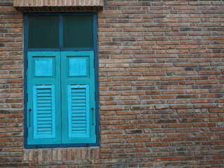Blue window made of wooden on old brick wall.