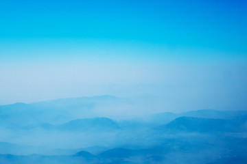 The mountains and forests with blue sky and white clouds at the peak of Inthanon national park (park name) in Chiang Mai province , Thailand in a foggy or misty day , real photo not graphic program.  