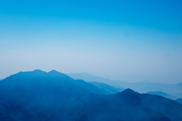 The mountains and forests with blue sky and white clouds at the peak of Inthanon national park (park name) in Chiang Mai province , Thailand in a foggy or misty day , real photo not graphic program.  