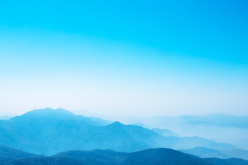 The mountains and forests with blue sky and white clouds at the peak of Inthanon national park (park name) in Chiang Mai province , Thailand in a foggy or misty day , real photo not graphic program.  