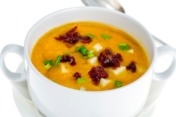 Vegetable soup cream with dried tomatoes and green onions.