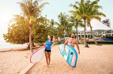 Two young surfers with boards on the beach