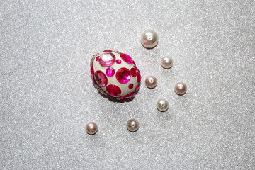 Easter composition flatlay. Easter eggs decorated with shiny rhinestones on  silver background with glass ornaments and pearl beads.