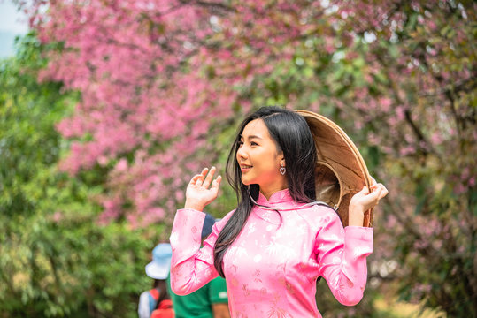 Beautiful young teenage girl wearing a pink posing in a park.