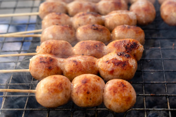 Grilled Thai sausage at street food market in Thailand. Traditional Thai sausage with pork and rice, delicious street food.