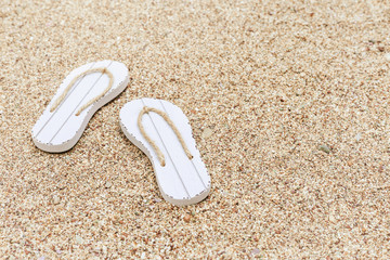 Summer shoes on sand. Beach flip flops. Summer background. Copy space. Selective focus.