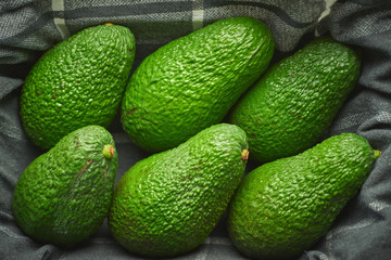 Seis aguacates encima de un paño de cocina