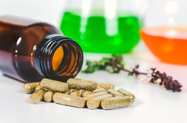 Alternative herb capsule spill out of bottle ,health concept.