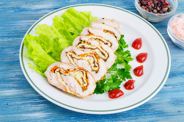 Plate of lettuce and slices of chicken roll.