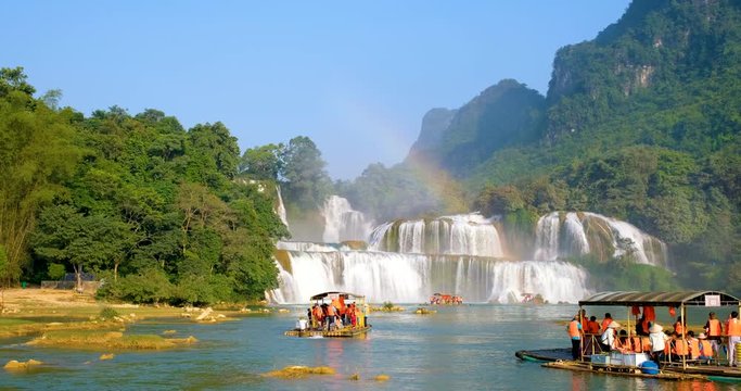 Cao Bang, Vietnam 10 2018: Tourist, traveller, tourism sightseeing waterfall and rainbow on wooden ferry. Ban Gioc waterfall or Detian waterfall is landmark in border Vietnam and Daxin County, China