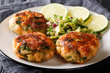 Healthy food salmon patties with fresh avocado salsa and lime closeup on a plate. horizontal