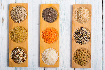 gluten free grains, seeds on bamboo plate, white wood table