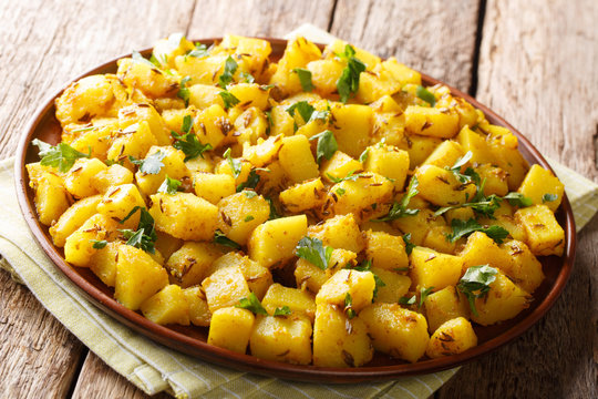 Jeera Aloo&nbsp;is a great side dish made with spiced potatoes cooked in chilli, cumin seeds close-up on a plate. Horizontal