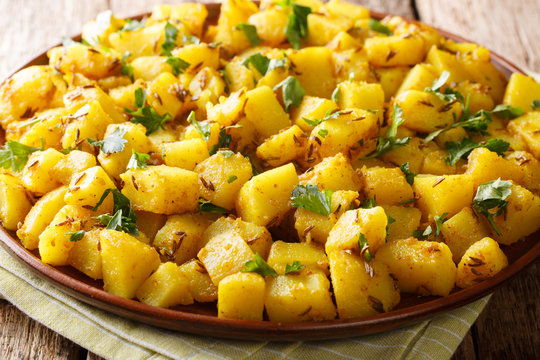 Jeera Aloo is a popular Indian side dish made with potatoes and cumin seeds close-up on a plate. horizontal