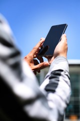 A man using smartphone in front of the office building.