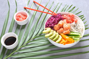 Fresh seafood recipe. Organic food. Fresh salmon poke bowl with crystal noodles, fresh red cabbage, avocado, cherry tomatoes. Food concept poke bowl 