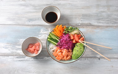 Fresh seafood recipe. Organic food. Fresh salmon poke bowl with crystal noodles, fresh red cabbage, avocado, cherry tomatoes. Food concept poke bowl 