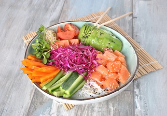 Fresh seafood recipe. Organic food. Fresh salmon poke bowl with crystal noodles, fresh red cabbage, avocado, cherry tomatoes. Food concept poke bowl 