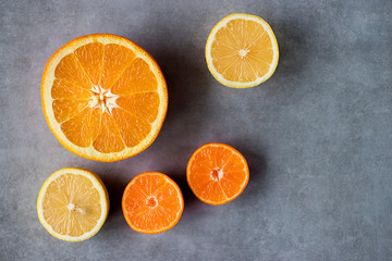 Slices of orange, lemon and mandarin on a gray background. Citrus fruit.