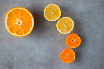 Slices of orange, lemon and mandarin on a gray background. Citrus fruit.