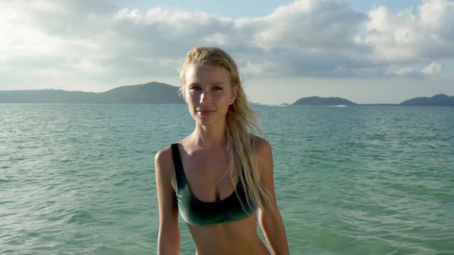 Stunning fit model with belly piercing wearing green bikini