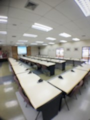 blurred image of empty auditorium room, interior of conference hall, seminar room with row of chair and table, Abstract blur for background usage.