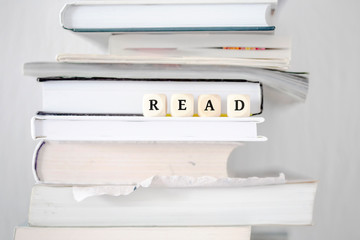 Books on desk and dice with word read as motivation