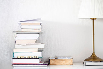  Books on desk with lamp and word knowledge as text motivation on dice