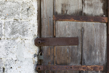 Old weathered door of wooden boards with a rusty locks.