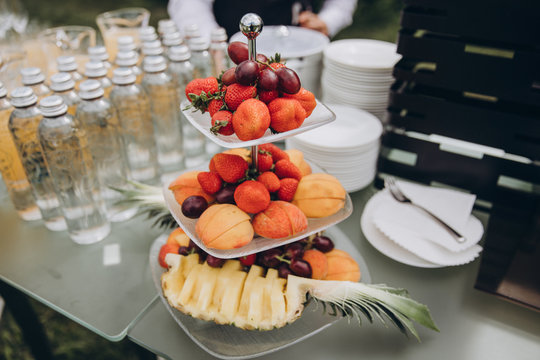 on buffet table are glasses and a plate of fruits