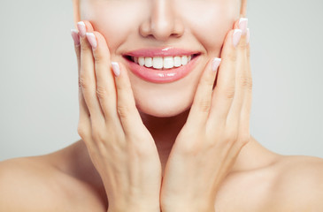 Obraz na płótnie Canvas Closeup female smile and manicured hand. French manicure, white teeth and pink glossy lips makeup
