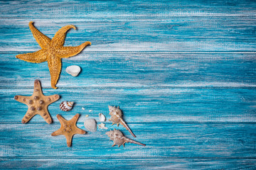 Starfish and seashells on blue background as concept of vacation time